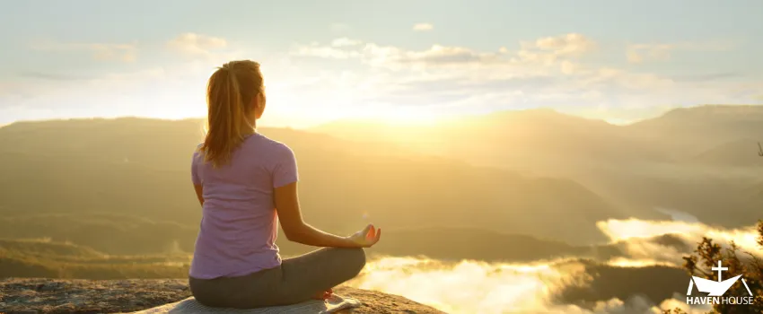HHRC - A woman meditating in the mountain