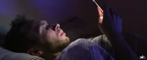 HHRC-Man using phone in bed